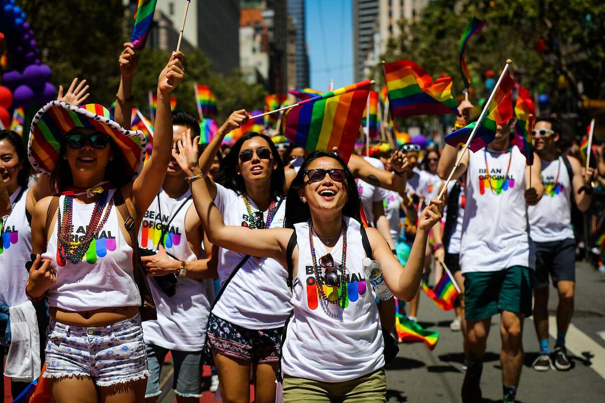 人随着音乐跳舞,而走在市场街,因为他们参加第46届同性恋骄傲游行,在旧金山,加州,周日,2016年6月26日。