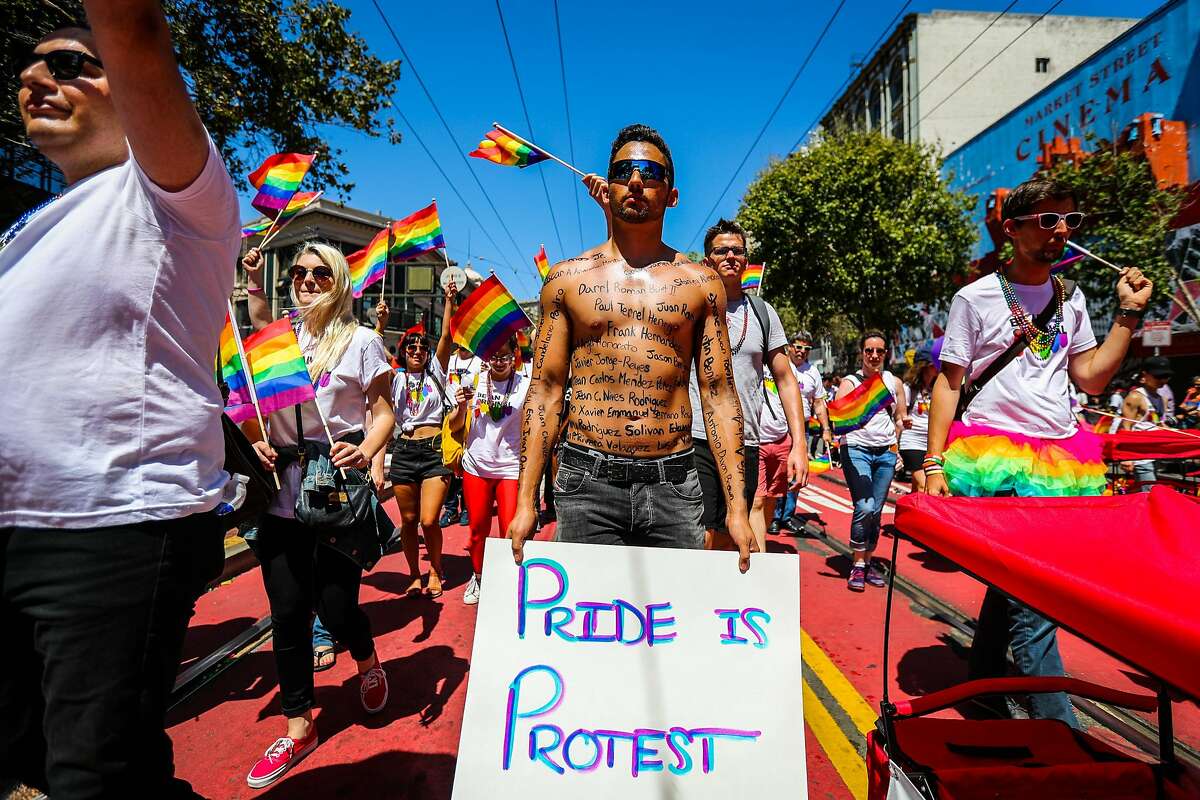 Thomas Pedrozza (center), bears the name of the Orlando victims across his body, as he walks in the 46th annual LGBT Pride Parade, in San Francisco, California, on Sunday, June 26, 2016.