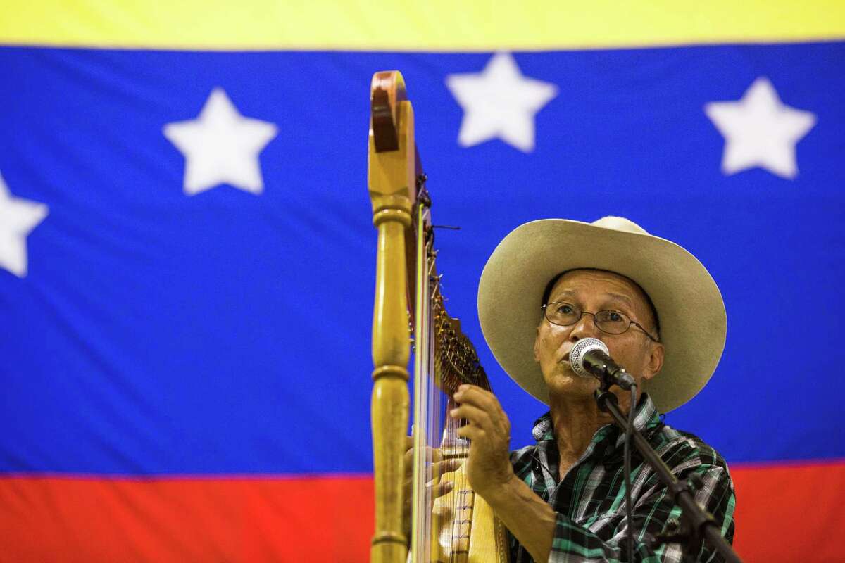 Singing and playing the harp at O.P. Schanbel Park, Rene Devia, of Colombia, plays the South American harp during a festival to raise money to aid victims of the economic and political hardship in Venezuela. A reader says those hardships were caused by the socialist regime in that country.