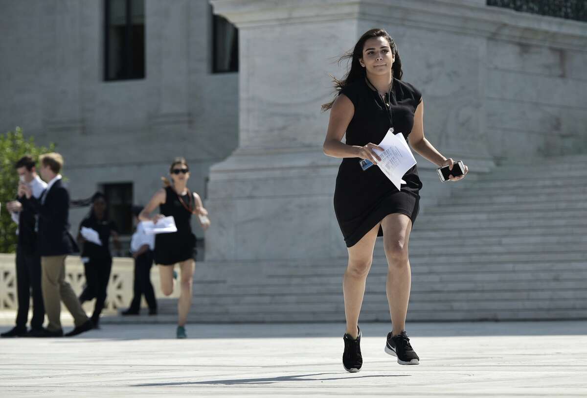 Reporters run out of the US Supreme Court after a ruling striking down a Texas law placing restrictions on abortion clinics, outside of the Supreme Court on June 27, 2016 in Washington, DC. In a case with far-reaching implications for millions of women across the United States, the court ruled 5-3 to strike down measures which activists say have forced more than half of Texas's abortion clinics to close.