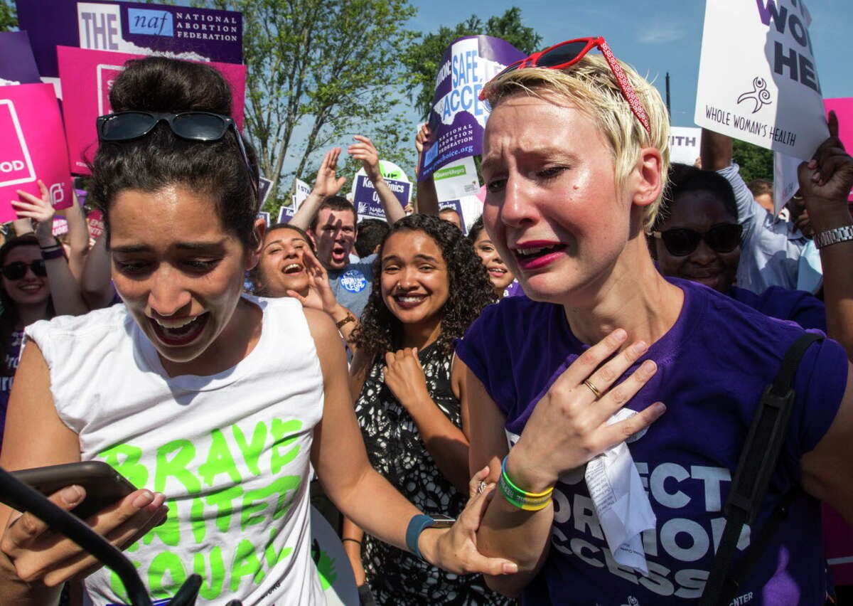 1859: The American Medical Association publishes a report calling for a crackdown on abortion. By the century’s end, abortion was illegal in every U.S. state.  Abortion rights activists Morgan Hopkins of Boston, left, and Alison Turkos of New York City, rejoice in front of the Supreme Court in Washington, Monday, June 27, 2016.