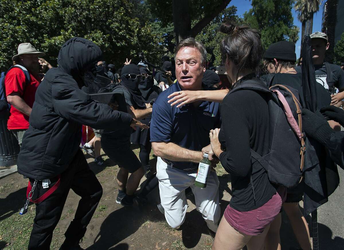 KCRA television reporter Mike Luery runs away from members of the group called ANTIFA Sacramento (Anti-Fascism Action), who are staging a counter-protest against the Traditionalist Worker Party and the Golden State Skinheads, at the California state Capitol in Sacramento, Calif., Sunday, June 26, 2016. Several people were stabbed Sunday when counter-protesters clashed with members of right-wing extremists groups that planned to hold a rally outside the Capitol building, authorities said. (Paul Kitagaki Jr./The Sacramento Bee via AP) MANDATORY CREDIT