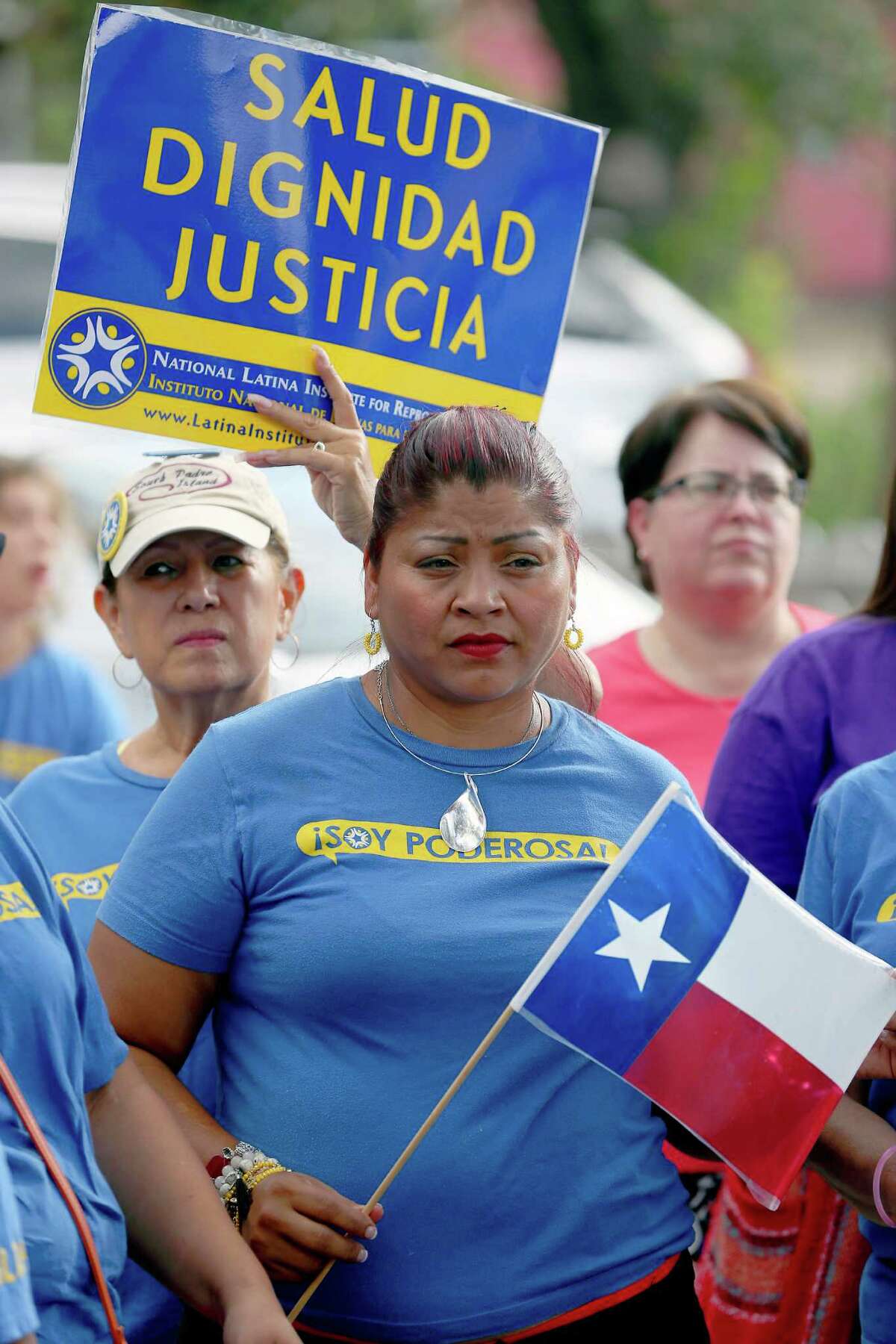 Marta Hernandez, holding Texas flag, listens during a news conference and rally Monday, June 27, 2016 at the Whole Woman's Health of McAllen clinic in McAllen. Members of the community had gathered there to celebrate the Supreme Court's 5-3 ruling that struck down a pair of strict Texas abortion regulations, sparing nearly a dozen clinics in the state from imminent closure.