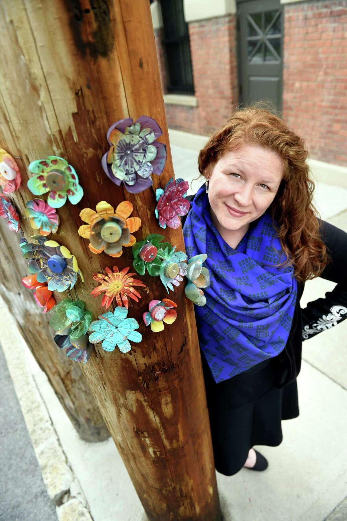 Executive Director Kristen Holler with a utility pole she decorated with flowers made from plastic bottles and caps on Tuesday, May 17, 2016, at the Albany Barn in Albany, N.Y. (Cindy Schultz / Times Union)