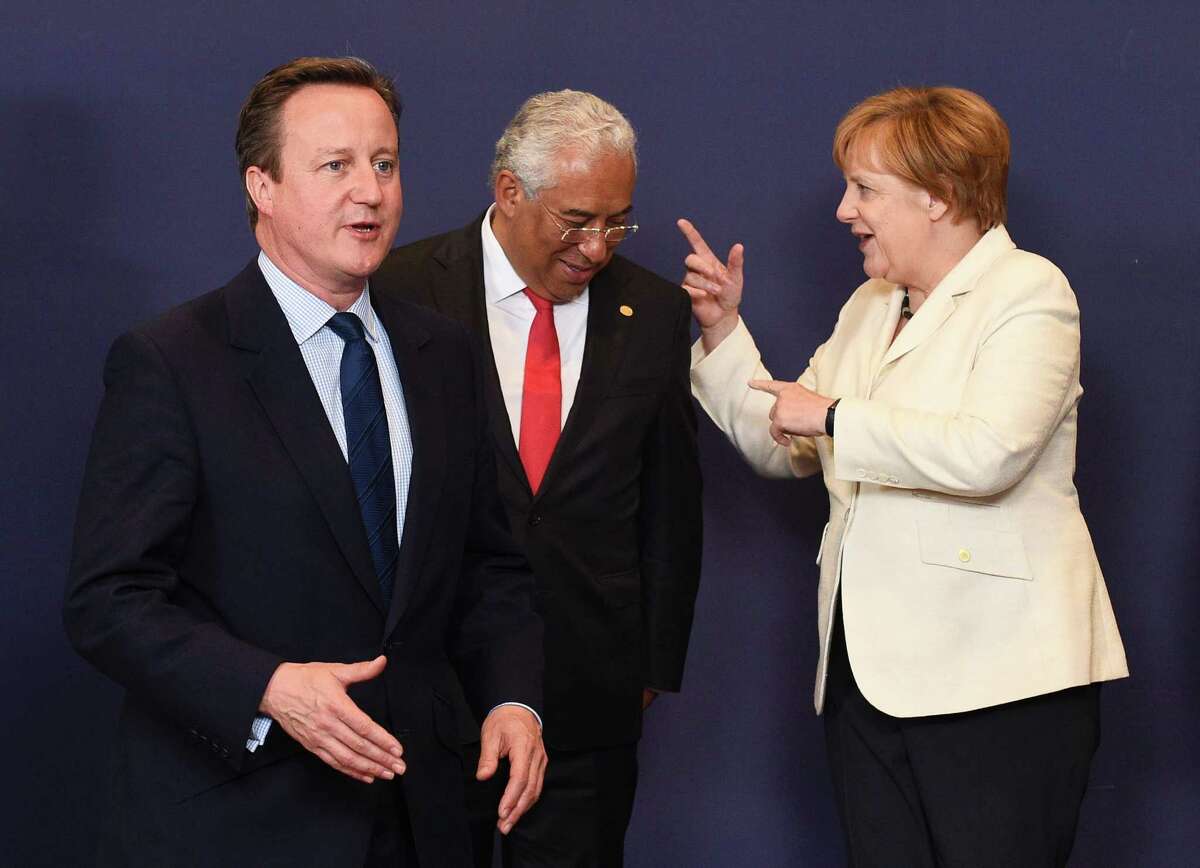 Britain Prime Minister David Cameron, left,﻿ gestures as Portuguese Prime Minister Antonio Costa talks with German Chancellor Angela Merkel﻿ in Brussels. ﻿