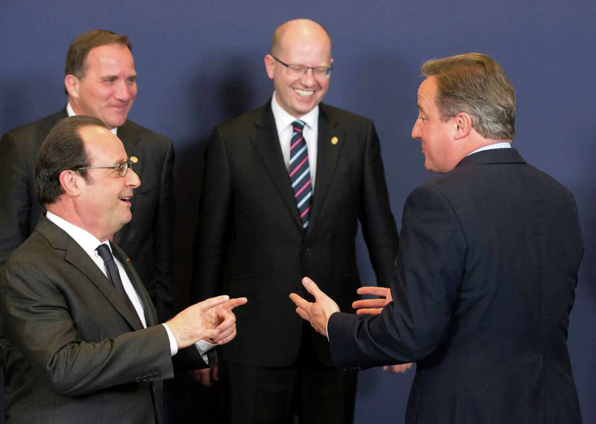 British Prime Minister David Cameron, right, speaks with French President Francois Hollande, left, during a group photo at an EU summit in Brussels on Tuesday, June 28, 2016. EU heads of state and government meet Tuesday and Wednesday in Brussels for the first time since Britain voted to leave the European Union, throwing British and European politics into disarray. (AP Photo/Geoffroy Van der Hasselt)