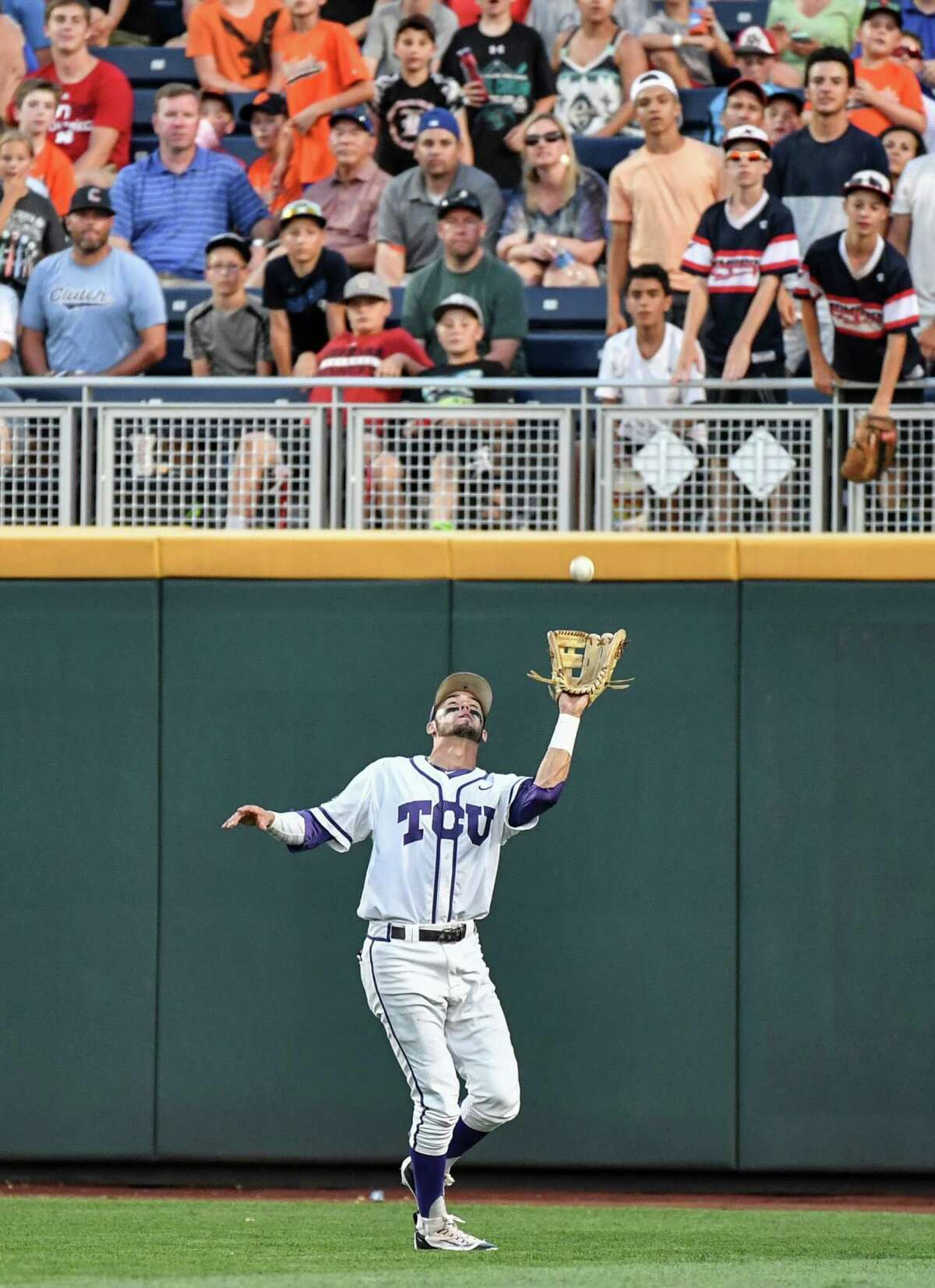 TCU center fielder Dane Steinhagen catches a fly ball by Coastal Carolina's G.K. Young during the seventh inning of an NCAA College World Series baseball game in Omaha, Neb., Friday, June 24, 2016. (AP Photo/Ted Kirk)