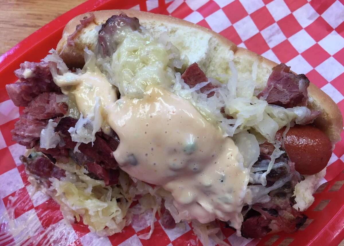 The Reuben Dog from Pugel’s hot dog restaurant features house-smoked corned beef, sauerkraut, Swiss cheese and thousand island dressing on a hot dog frank.