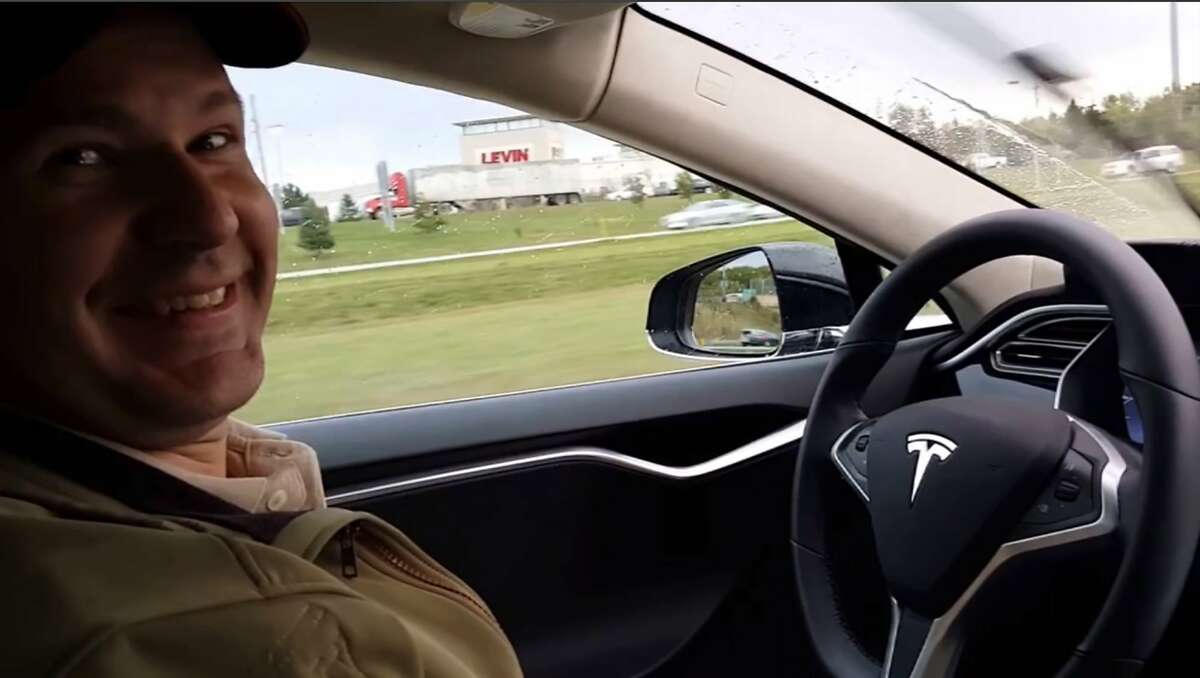 This still image taken from a video published on YouTube on Oct. 15, 2015, shows Joshua Brown of Canton, Ohio, in the driver's seat of his Tesla Model S with no hands on the steering wheel while he demonstrates the car's self-driving mode. Brown was killed on May 7, 2016, in Williston, Fla., when his car hit a tractor-trailer while it was on the Autopilot system. (YouTube via AP)