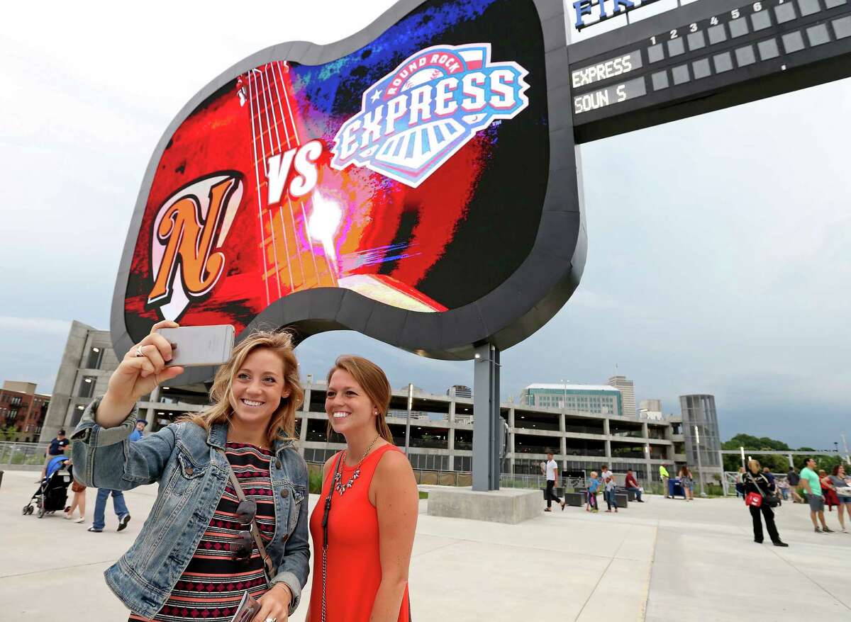 Sisters Lynn (left) and Angela Lazzeretti take a selfie with the scoreboard at First Tennessee Park before the Nashville Sounds and Round Rock Express baseball game Friday June 3, 2016 in Nashville, Tennessee.