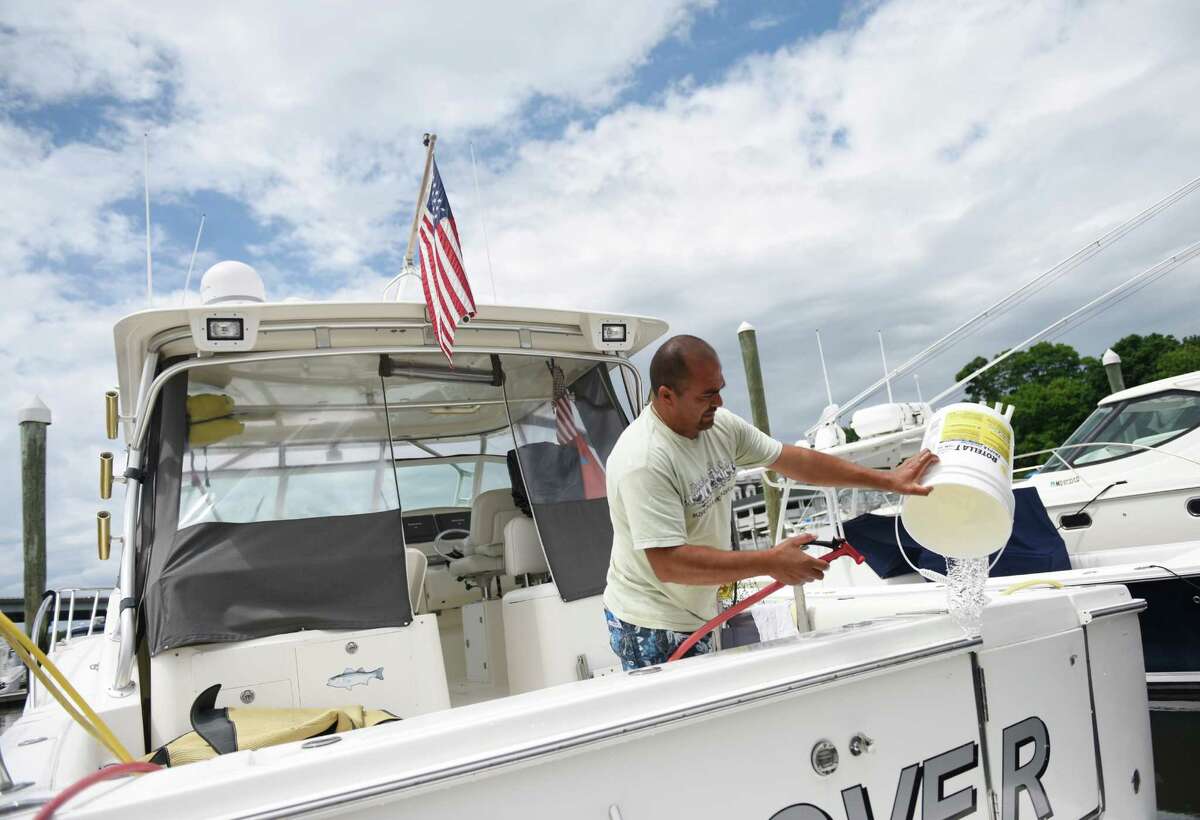 Rene Garrido, of Stamford, cleans his boat docked at the Greenwich Water Club in the Cos Cob section of Greenwich, Conn. Wednesday, June 8, 2016. Connecticut has lost more than 10 percent of its commercial and recreational fleet over the past 10 years.