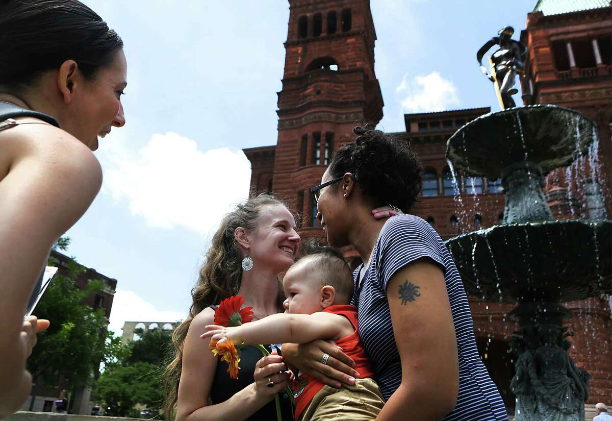 Minister Leilani Long, left, pronounces Liz Moseley, right, and Gabby Bonar married as the couple holds Langston Moseley in front of the Bexar County Courthouse. Gay couples were able to get their marriage license at the Bexar County Courthouse after the Supreme Court voted in favor of same sex weddings, on Friday, June 26, 2015. Some of the couple were married in the Presiding Court the same day.