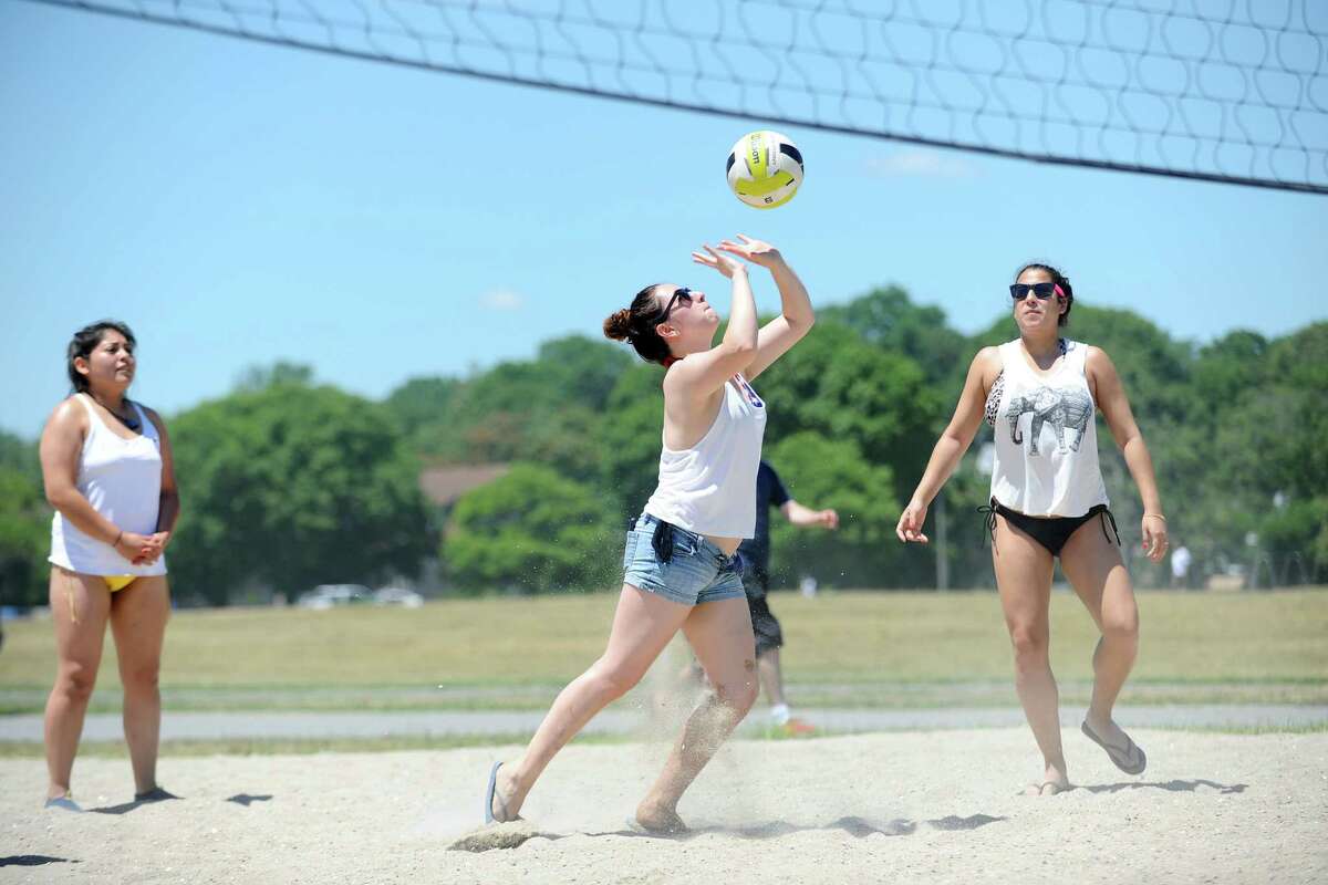 Paula Aleman, 23, hits a volleyball over the net while playing with her friends at Cove Island Beach on Monday, July 4, 2016.