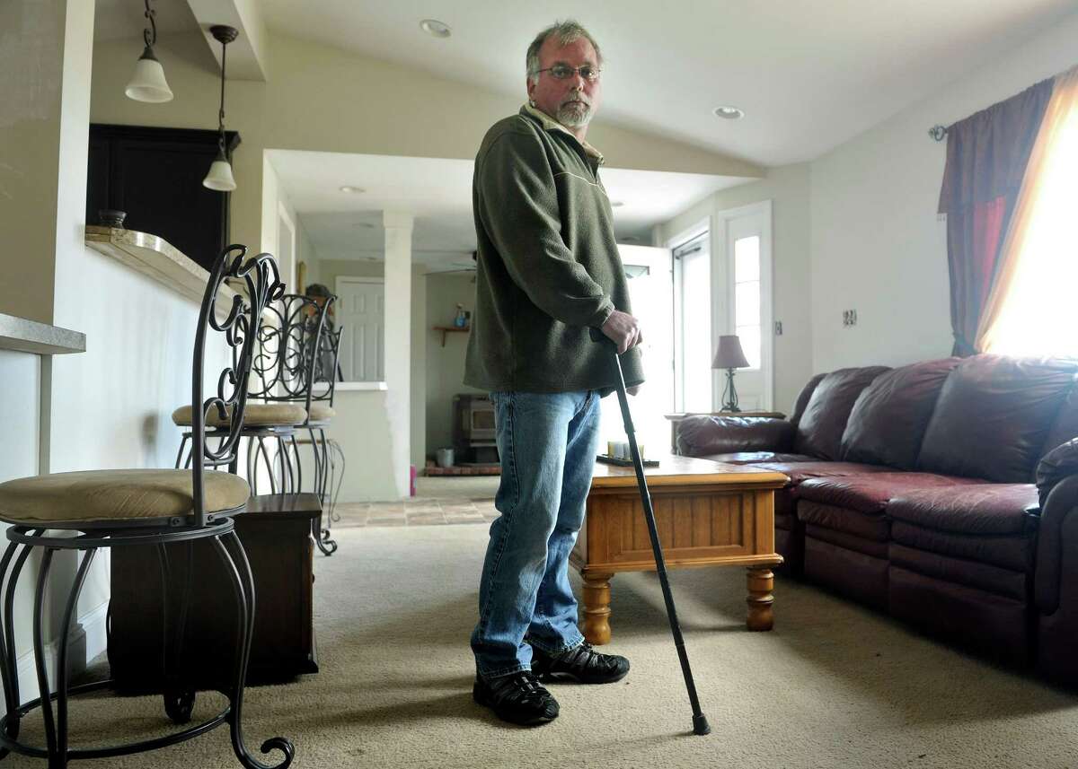 Richard Tesiero, who lives in Fort Johnson, hasn't been able to work full time since he came down with a mysterious illness. He has to use a cane because of his health problems. (Paul Buckowski / Times Union)