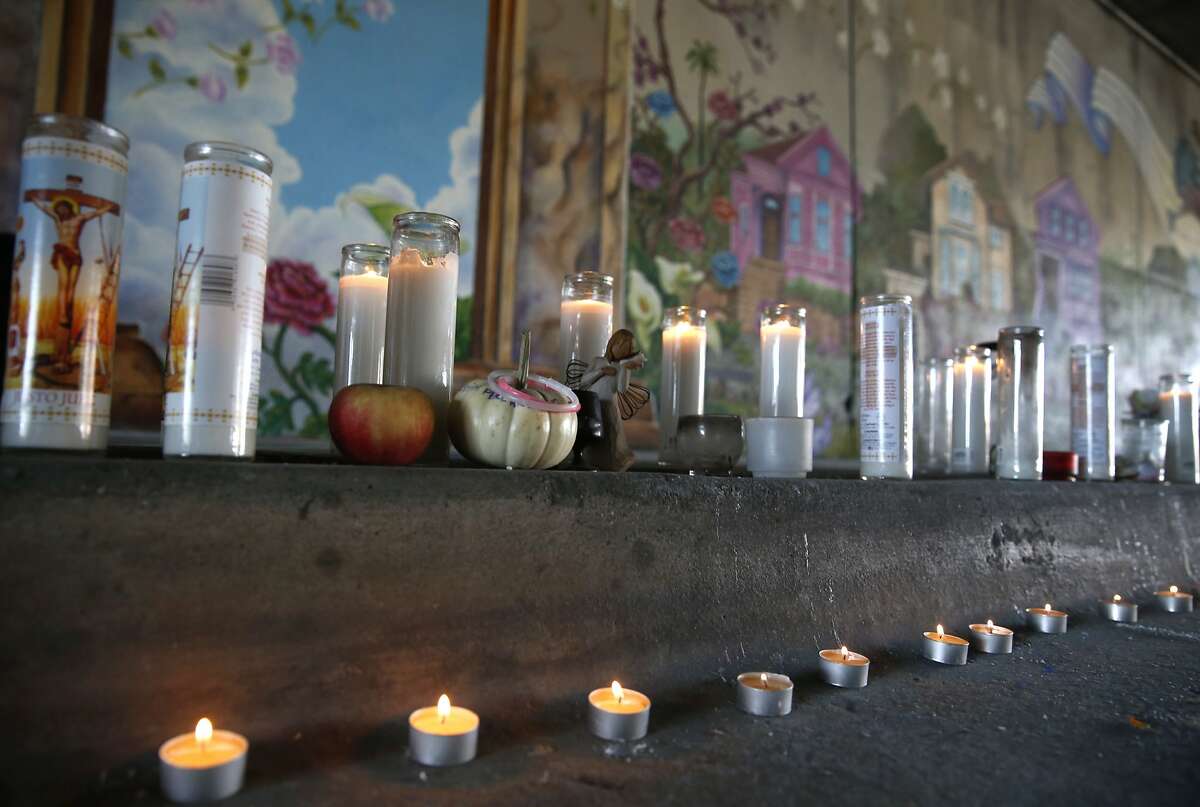 Candles line the curb at a dedication ceremony for the Superheroes Mural Project on West Street in Oakland, Calif. on Wednesday, Oct. 21, 2015. Artist Antonio Ramos was shot and killed while working on the mural on Sept. 29.