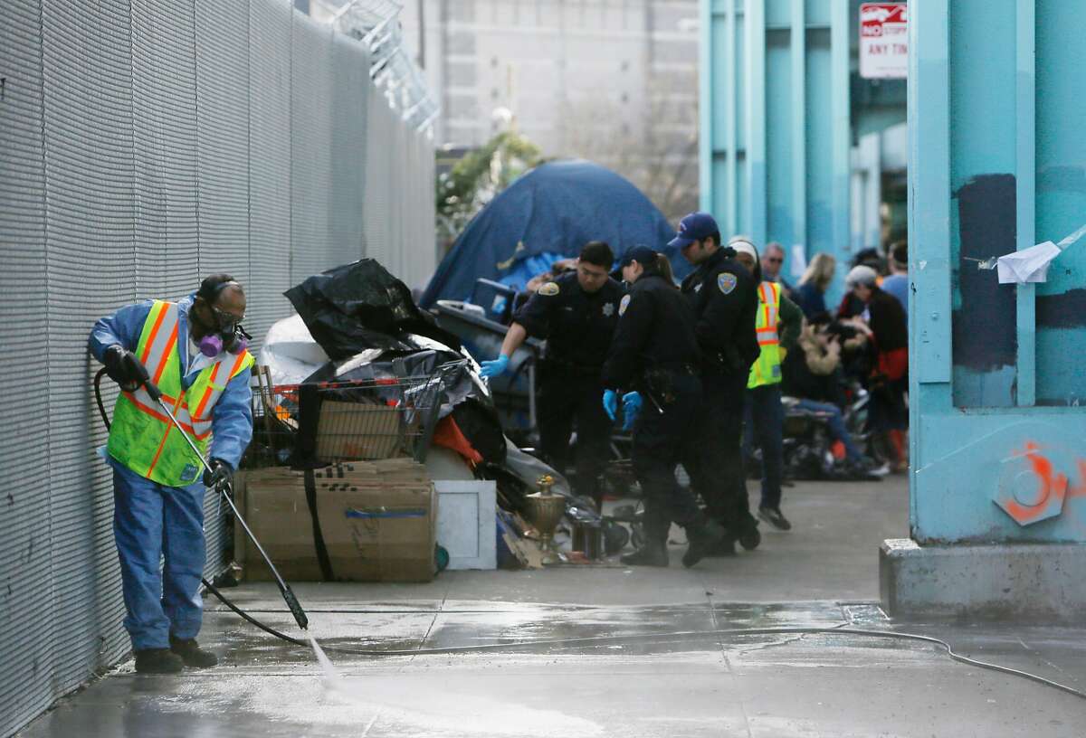 A Department of Public Works member cleans 13th Street as city work crews clear out a homeless encampment along 13th Street in the morning on Tuesday, March 1, 2016 in San Francisco, California.