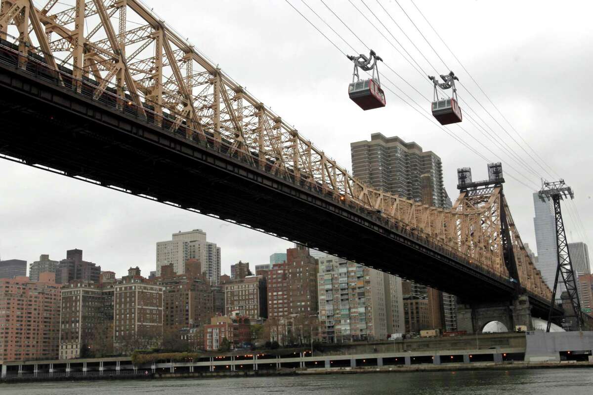 The Roosevelt Island trams are framed by the Queensboro Bridge and the Manhattan skyline as they make their way over the East River into Roosevelt Island, Tuesday, Nov. 30, 2010, in New York. (AP Photo/Mary Altaffer)