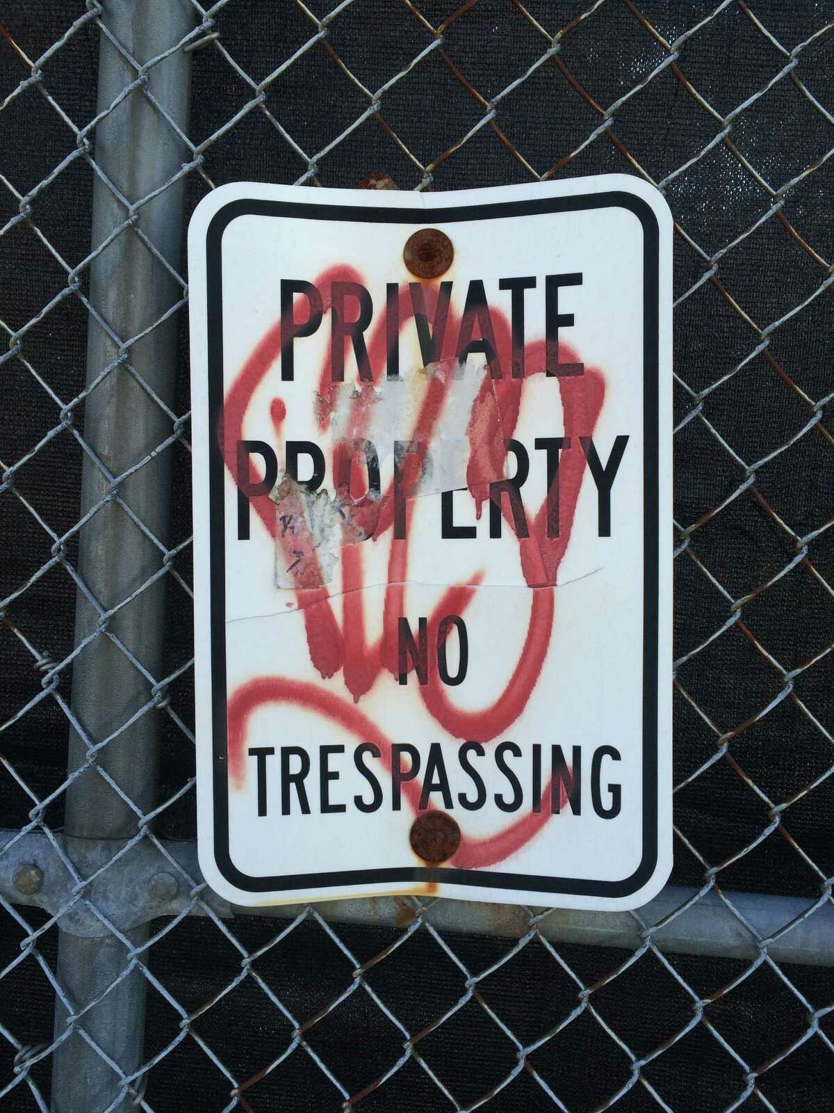 A vandalized sign on the fence surrounding the former Schenectady International factory site on 10th Avenue in Schenectady as seen on April 27, 2016. The DEC first began talks with the company to clean up the property in the 1990s. A finish of the remediation is expected in summer 2016. (Lauren Stanforth)