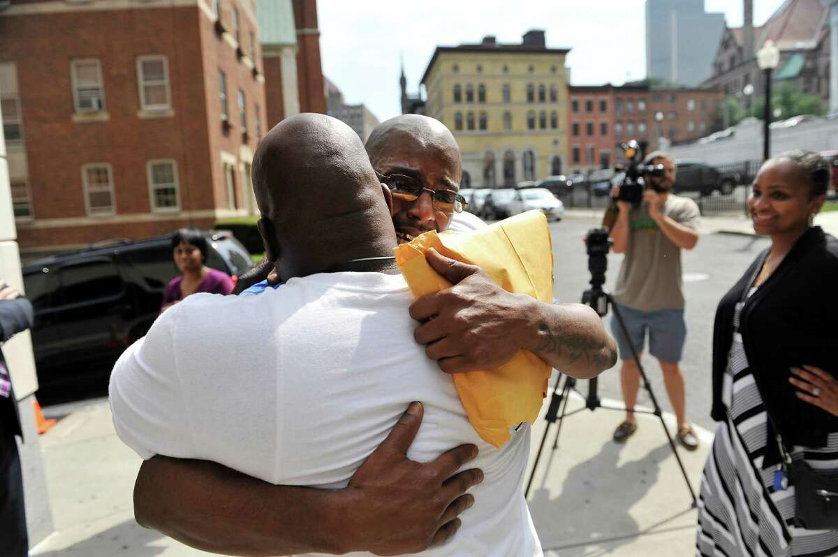 Carl Dukes, right, hugs his cousin, Jamal Hameed outside the Albany County Judicial Center on Thursday, July 7, 2016, in Albany, N.Y. Dukes, who was imprisoned for the 1997 killing of Erik Mitchell, a University at Albany student, was exonerated of the crime. Another man has been implicated in the killing. (Paul Buckowski / Times Union)
