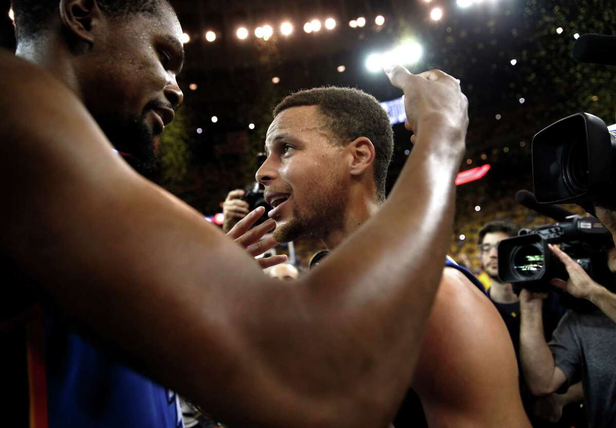 Golden State Warriors' Stephen Curry and Oklahoma City Thunder's Kevin Durant meet after Warriors' 96-88 win in Game 7 of NBA Playoffs' Western Conference finals at Oracle Arena in Oakland, Calif., on Monday, May 30, 2016.