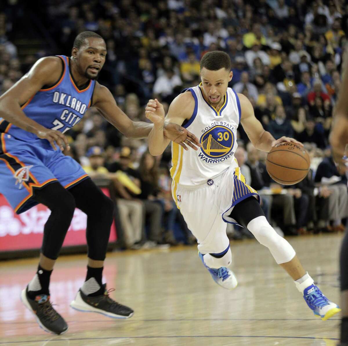 Stephen Curry (30) drives to the basket defended by Kevin Durant (35) as the Golden State Warriors played the Oklahoma City Thunder at Oracle Arena in Oakland, Calif., on Thursday, March 3, 2016.