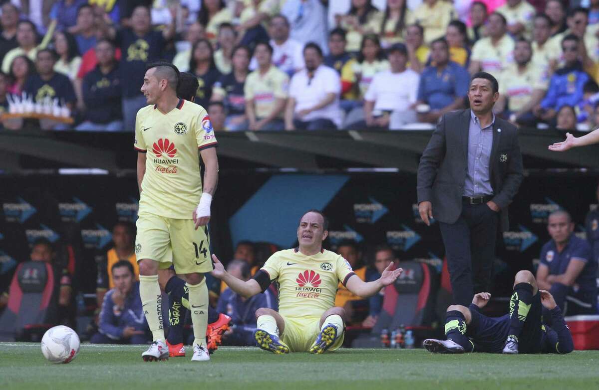 Club America’s Cuauhtemoc Blanco (center) reacts as the referee signals a foul against Morelia´s Facundo Erpen (on ground at right) during a Mexican League soccer match, in Mexico City on March 5, 2016. Pictured at left is America’s Rubens Sambueza and coach Ignacio Ambriz, back right.