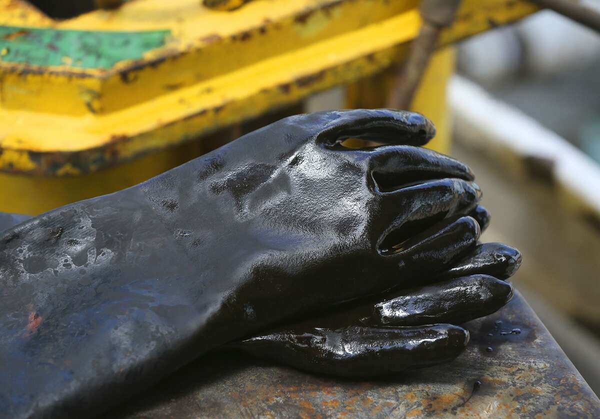 Oil covered gloves are placed on the Abraxas Petroleum Bullseye 101H well Monday June 27, 2016 in Atascosa County near Jourdanton, Texas. Even as some oil companies like Royal Dutch Shell and BP predict oil demand will peak before 2040 — as electric vehicles hit the road and governments worldwide work to cut greenhouse gas emissions — there are plenty within the oil industry who view such predictions with a healthy skepticism.