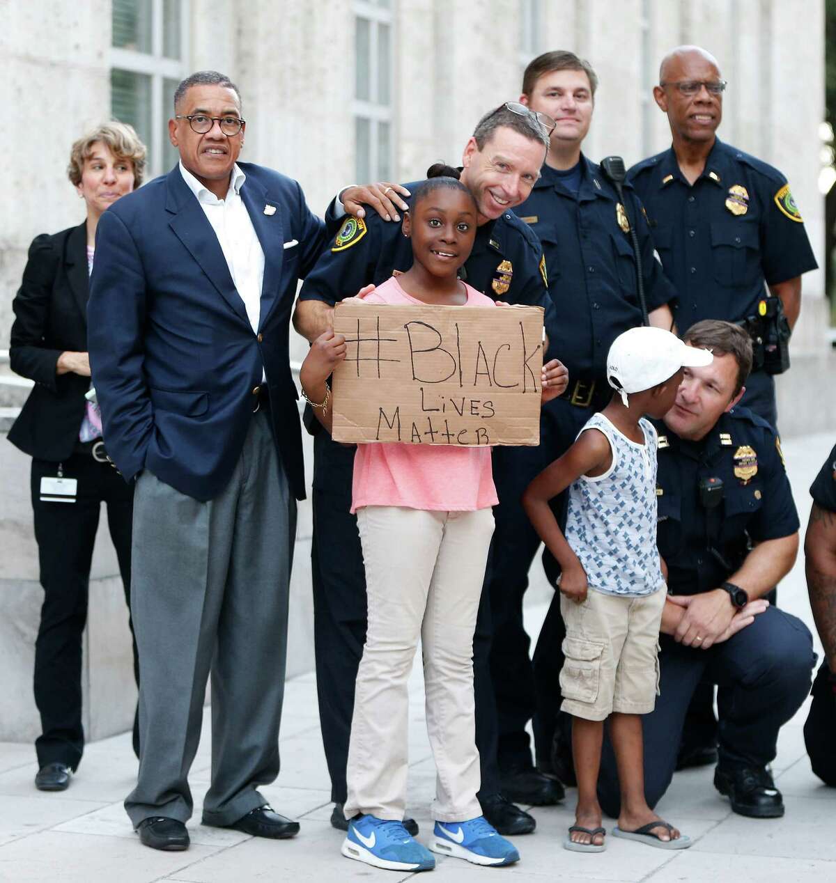 Houston police take photos with protesters during the rally that began at Discovery Green and ended at City Hall on Friday.