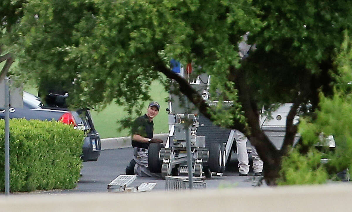 Police appear to setup a remotely operated robot during a stand off with a gunman barricaded inside a van at a Jack in the Box restaurant at Interstate 45 and Dowdy Ferry Road, Saturday, June 13, 2015, in Hutchins, Texas. The gunman allegedly attacked Dallas Police Headquarters. The robot may be similar to one used by the The Dallas Police Department which had a similar robot, according to a post on its Facebook page last year, though the department has not confirmed if it was the one used against a gunman who killed five officers Thursday evening. An expert said he believes it was the first time police anywhere used a robot to deliver a bomb during any kind of tactical situation. The gunman was killed by the explosion.(AP Photo/Brandon Wade)