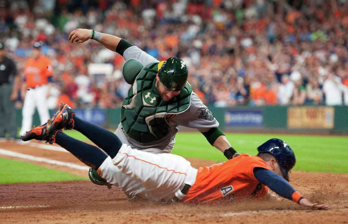 Oakland Athletics catcher Stephen Vogt, top, tags out the Houston Astros' Jose Altuve in the fifth inning of a baseball game Friday, July 8, 2016, in Houston. (AP Photo/George Bridges)