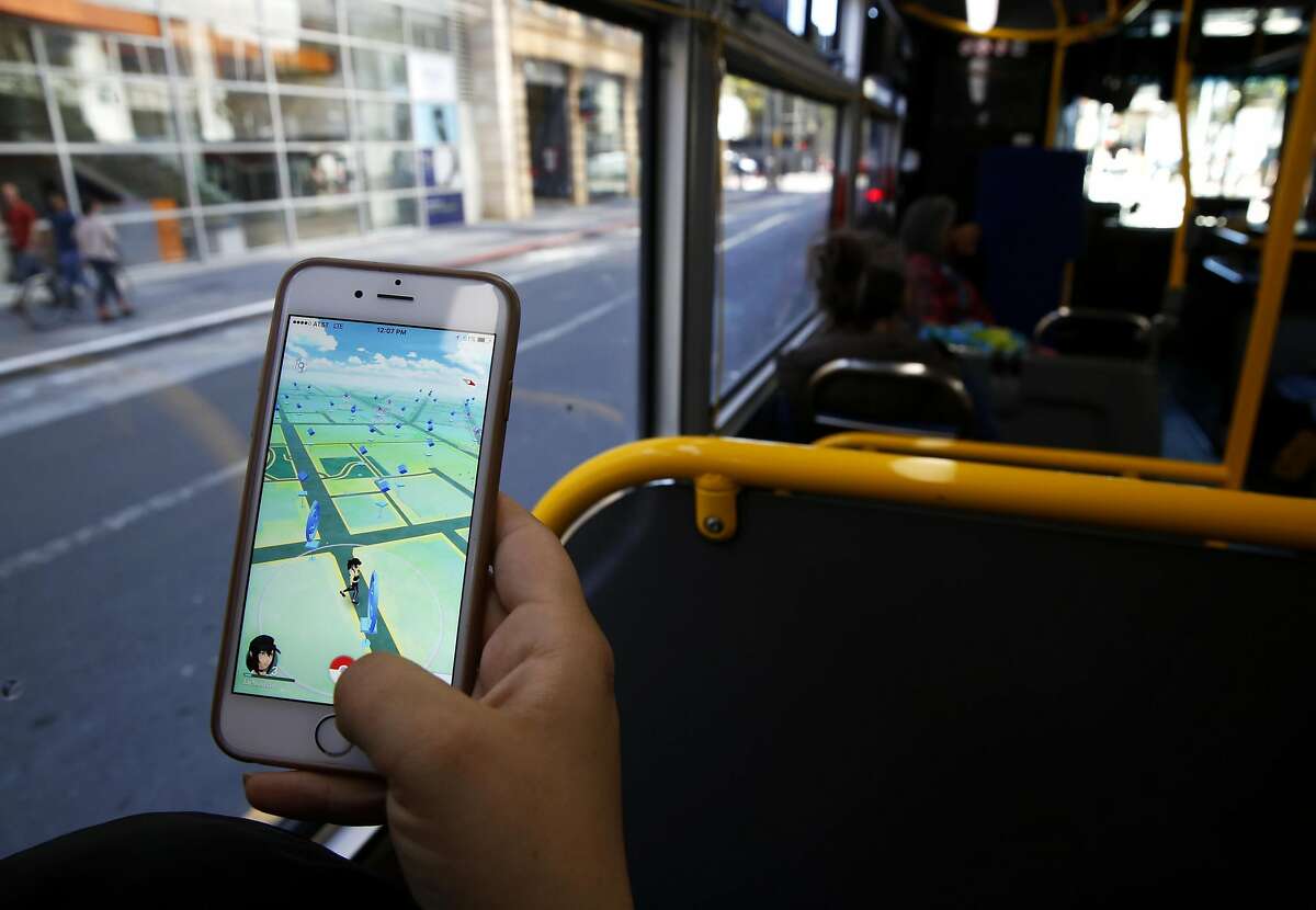 A woman plays Pokemon Go while riding on a bus through downtown San Francisco, California, on Monday, July 11, 2016.