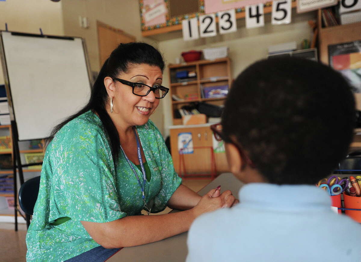 Teaching assistant Margie Perez works with a student in a kindergarten classroom at Blackham School in Bridgeport, Conn. on Tuesday, June 7, 2016. Teaching assistants' jobs are on the Board of Education chopping block as it faces a huge budget shortfall next year.