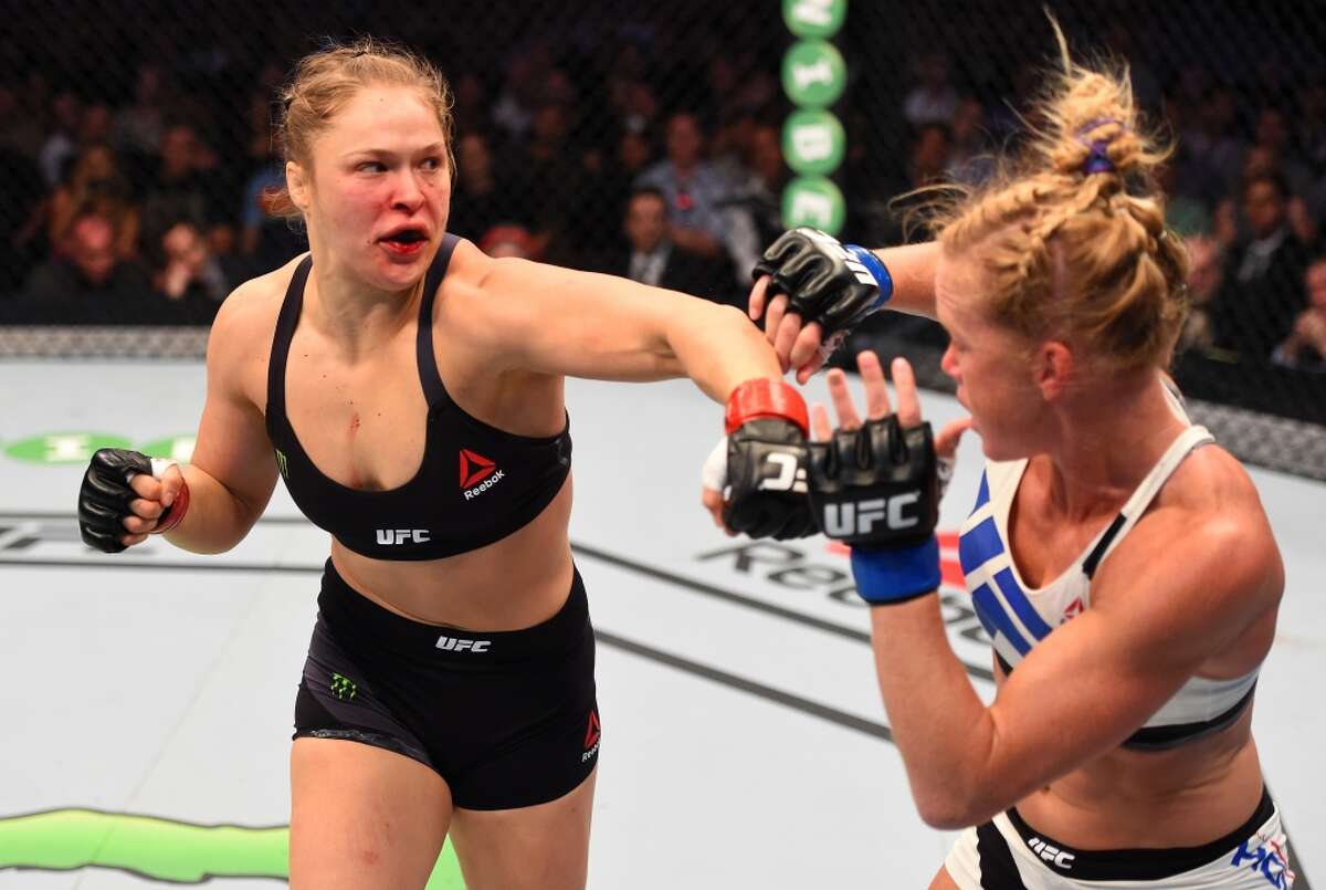 Ronda Rousey (left) punches Holly Holm in their UFC women's bantamweight championship bout during the UFC 193 event at Etihad Stadium on November 15, 2015 in Melbourne, Australia.
