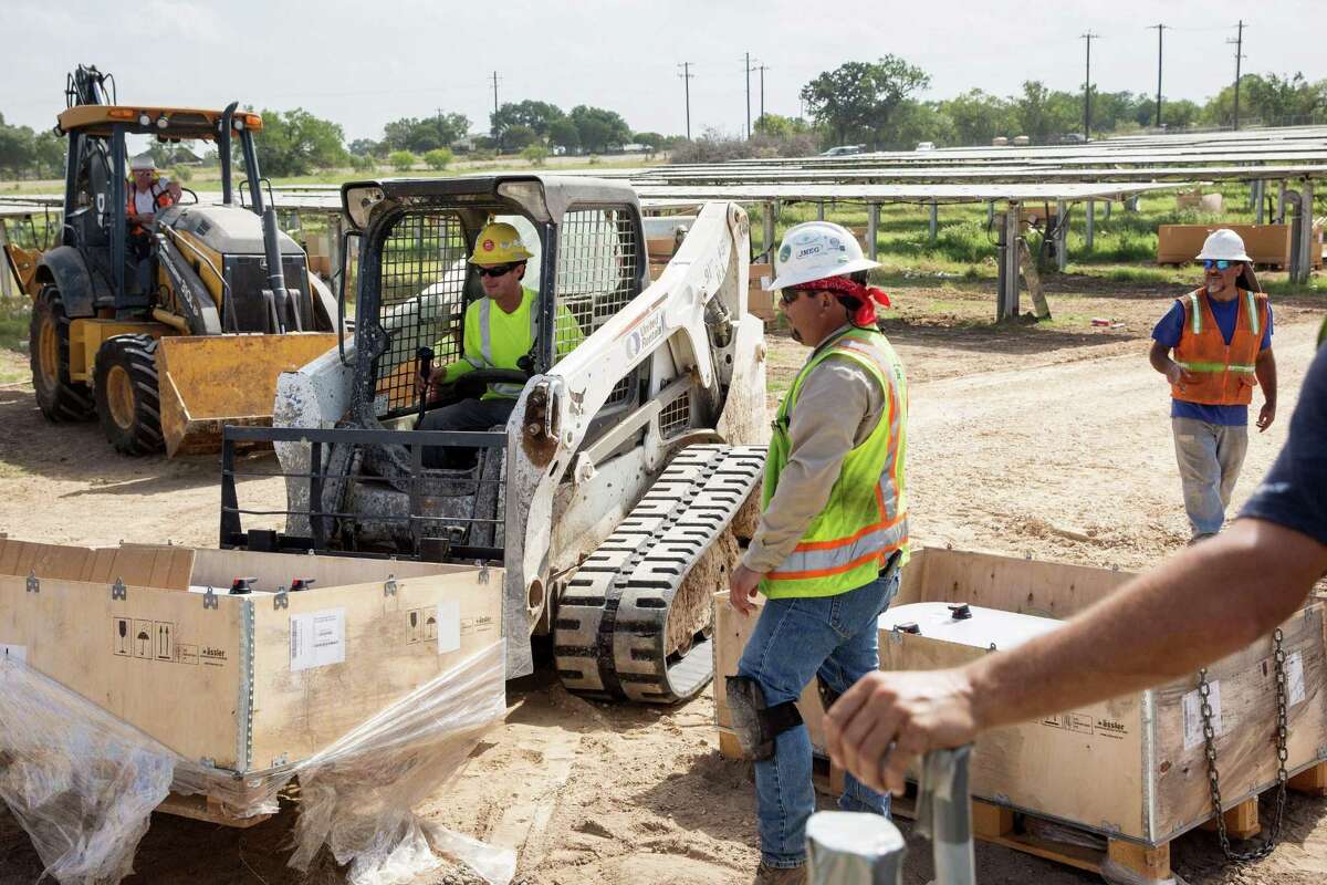 Construction workers prepare to install an inverter at a solar farm in Adkins. A new study shows that solar jobs in Bexar County increased from 572 in 2015 to 1,665 in 2016, accounting for nearly half the solar job growth in Texas for 2016.