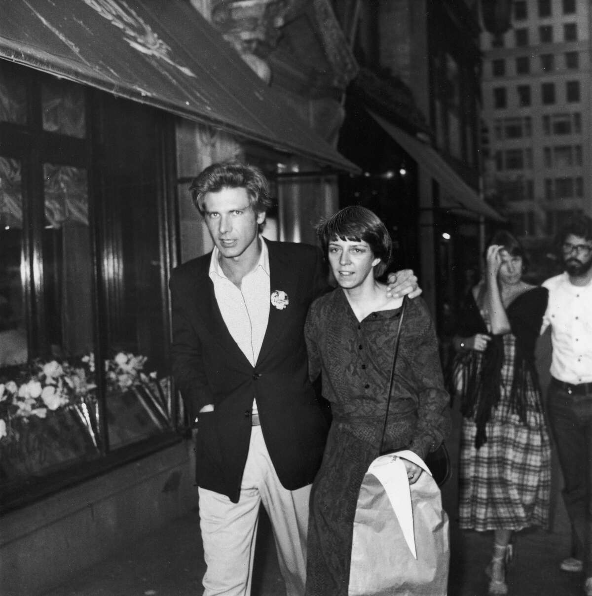 June 1977: American actor Harrison Ford and wife, Mary Marquardt, walking in New York City. Filmmaker George Lucas and wife, Marcia, walk behind them. Images)
