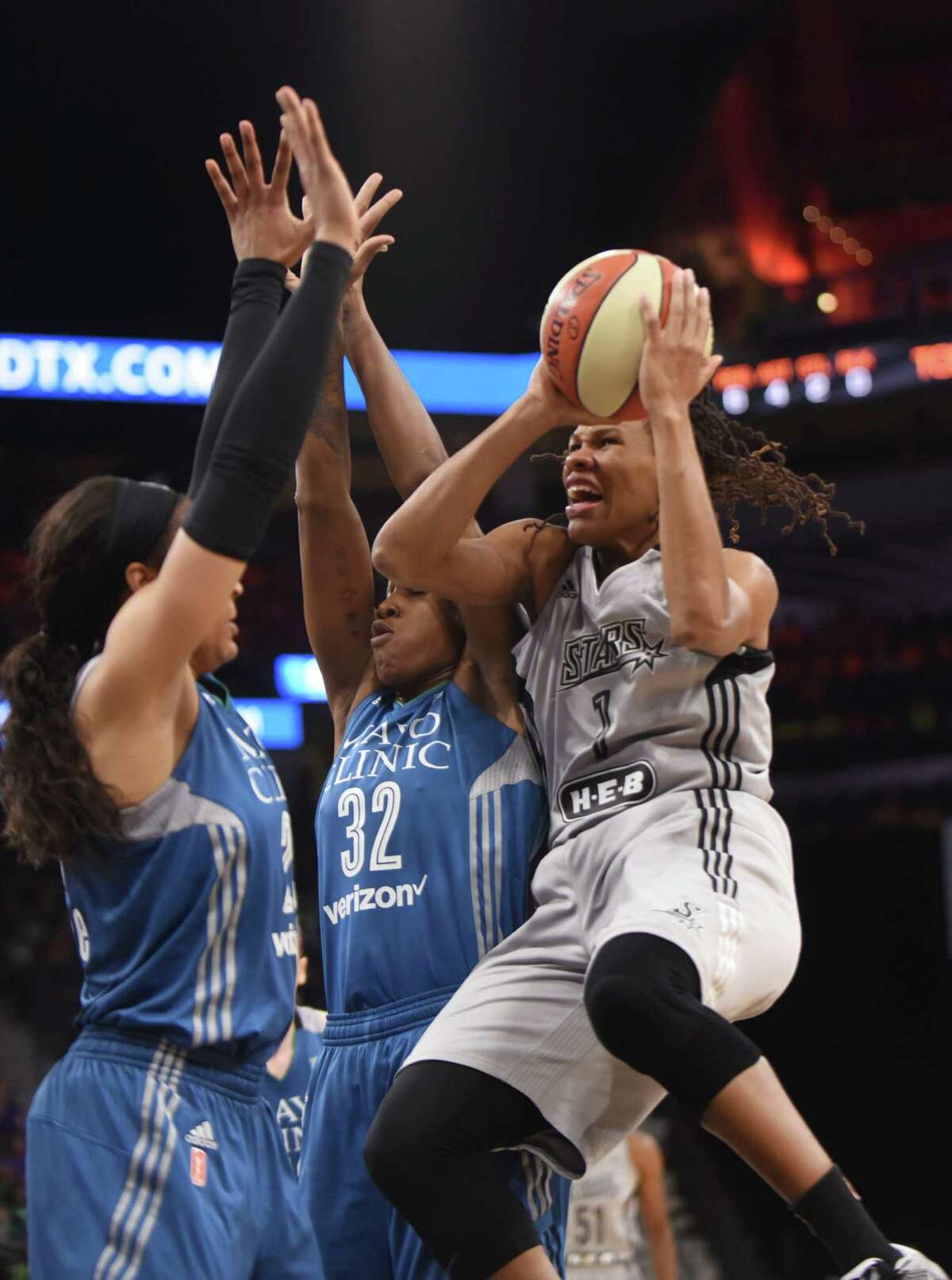 The Stars’ Monique Currie (1) of the San Antonio Stars drives to shoot as Minnesota's Maya Moore, left, and Rebekkah Brunson defend during WNBA action in the AT&T Center on Tuesday, July 12, 2016.