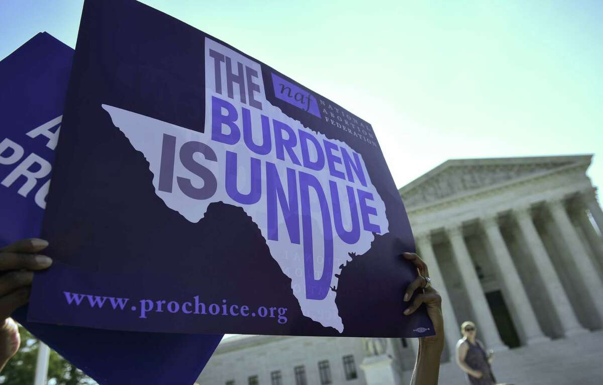 An abortion rights activist holds placards outside of the U.S. Supreme Court before the Court struck down a Texas law placing restrictions on abortion clinics on June 27 in Washington, D.C.. (AFP/Getty Images)
