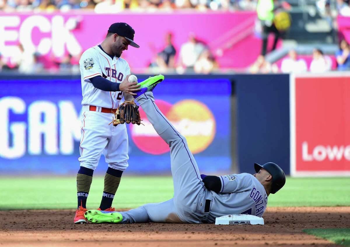 Astros second baseman Jose Altuve engages in one of the game's playful moments with the Rockies' Carlos Gonzalez.