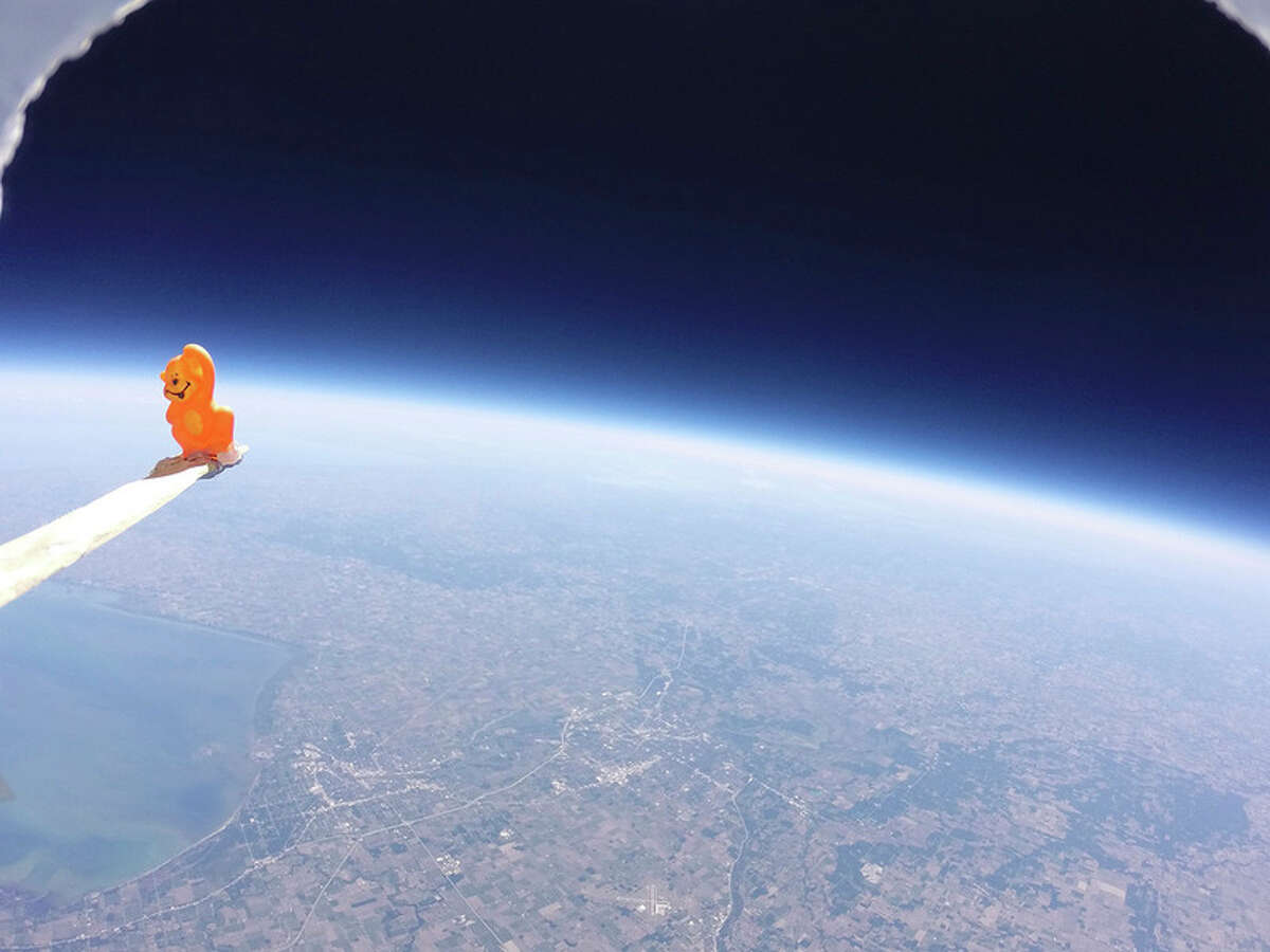 Photo provided 'Bananas,' the mascot for the Northeast Middle School balloon, provides a reference point for the flight. The Earth's atmosphere is visible from the height of the payload hanging below the weather balloon built by Northeast Middle School students.