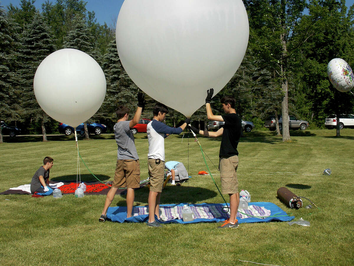 Photo provided Midland High School students prepare their balloon for flight at the Lost Arrow Resort in Gladwin. Students from Northeast Middle School's Science Club and Midland High School's Electronics and Wireless Communications Club launched their culminating STEM project, weather balloons, over the skies of Midland.