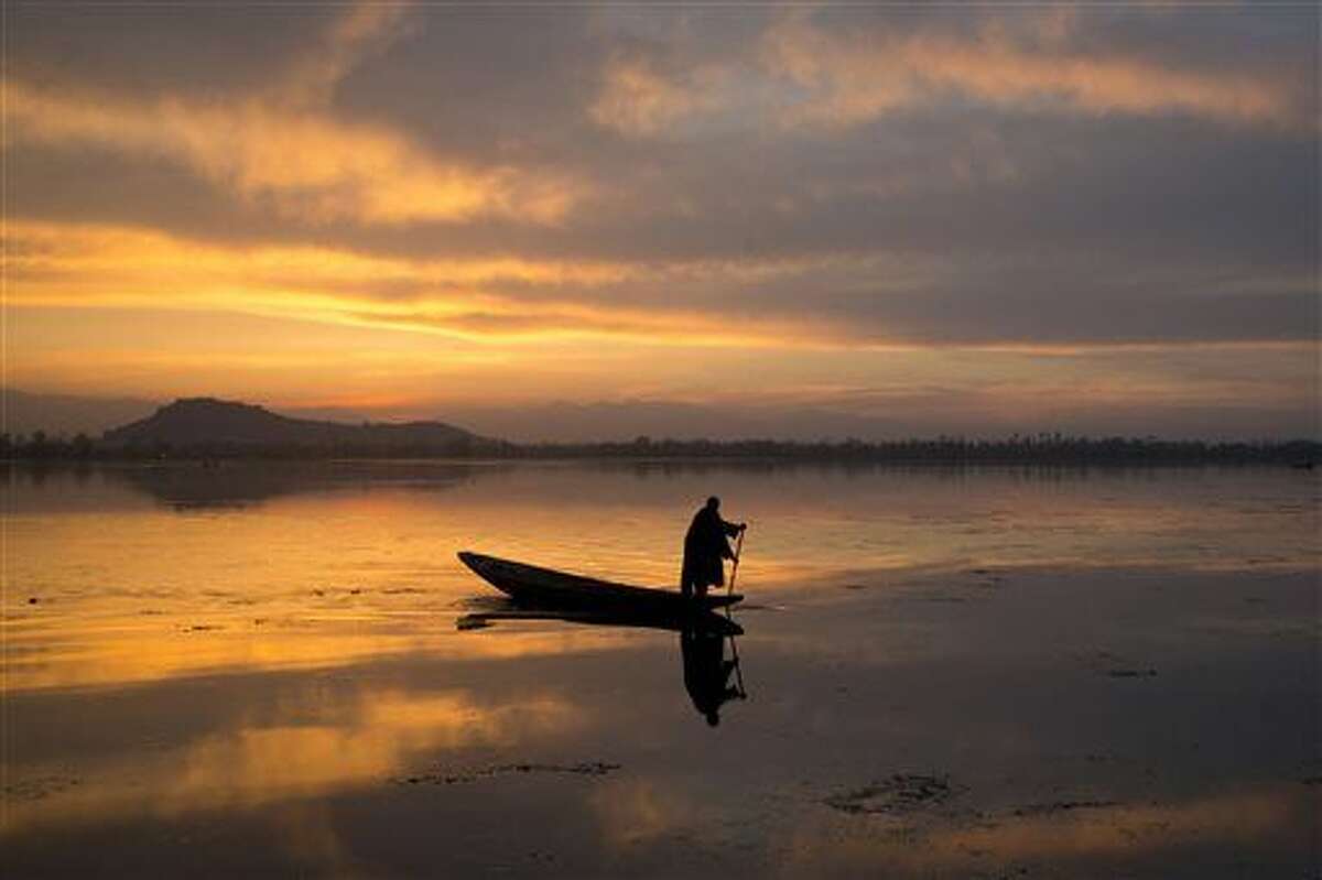 A Kashmiri fisherman rows his Shikara, or traditional boat, during sunset at the Dal Lake in Srinagar, Indian controlled Kashmir, Tuesday, March 29. Nestled in the Himalayan mountains and known for its beautiful lakes and saucer-shaped valleys, the Indian portion of Kashmir is also one of the most militarized places on earth.