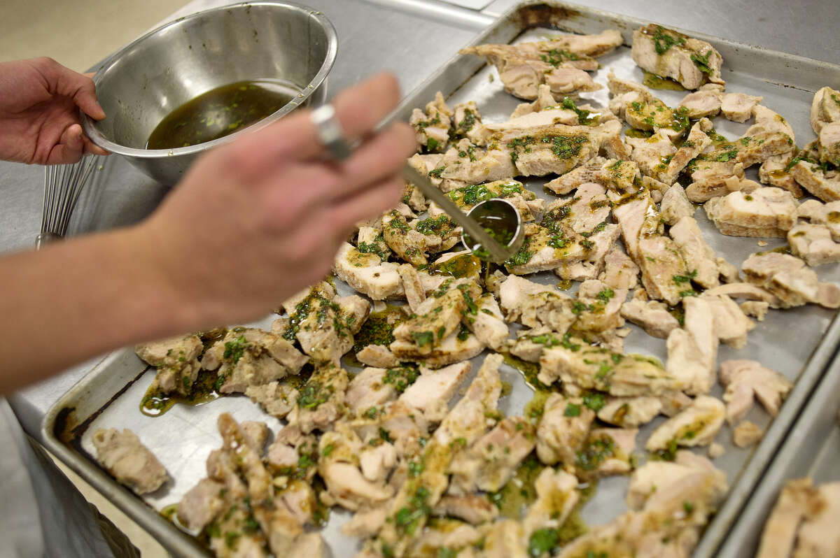NICK KING | nking@mdn.net Israel Gonzalez pours a marinade over chicken while preparing fajitas during a culinary class on Monday at Windover High School.