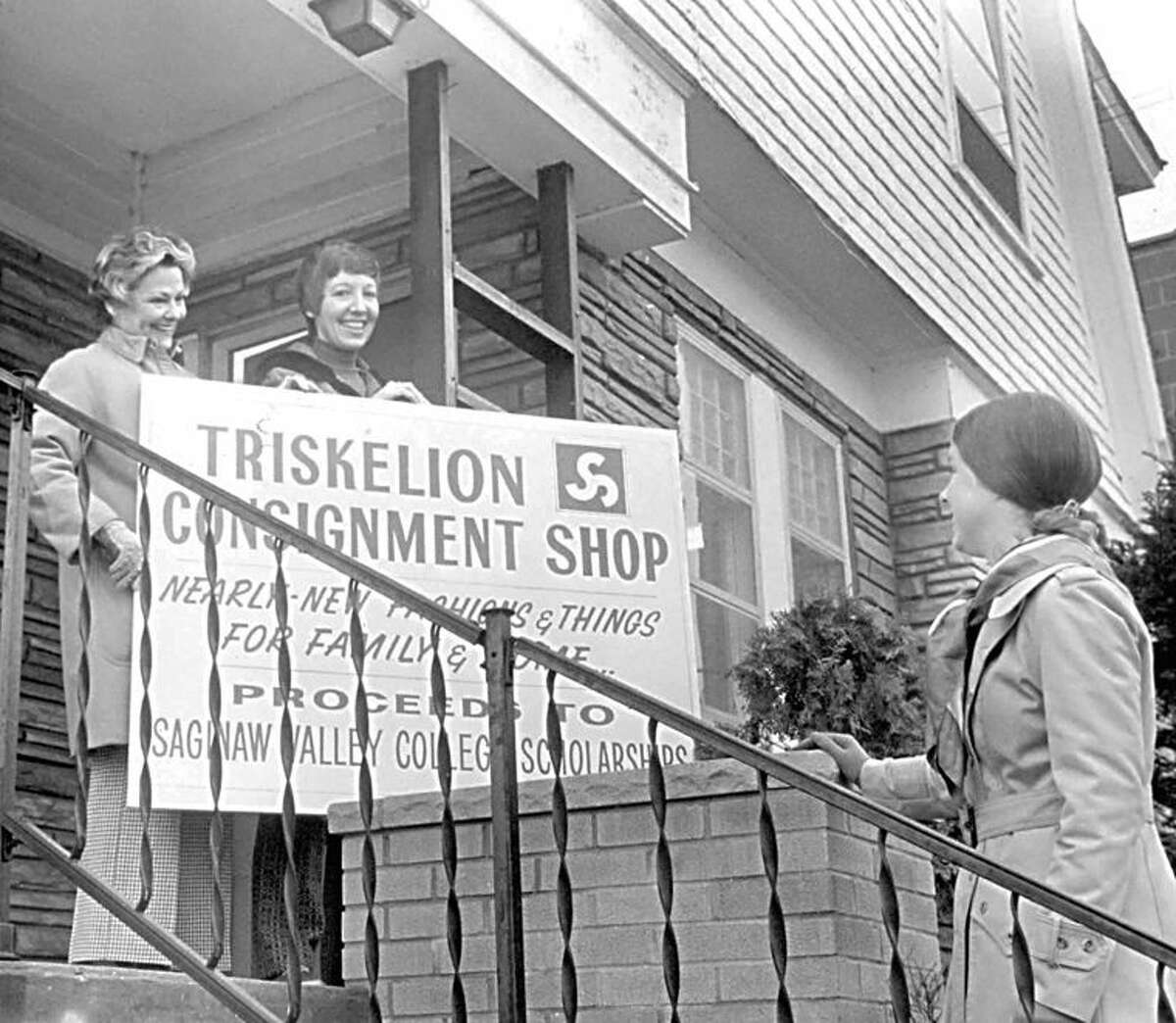 Moving Day: Mrs. Harriet Hutchenreuter, Mrs. Rhosan Stryker and Mrs. Jan Jones survey the new sign for the Triskelion Consignment Shop. The store, which sells next to new clothing to area residents, will be moving to the corner of Larkin and Townsend streets. The Triskelion shop is manned by volunteers and was organized to earn scholarship money for Saginaw Valley College. (First published March 13, 1974, in the Daily News)