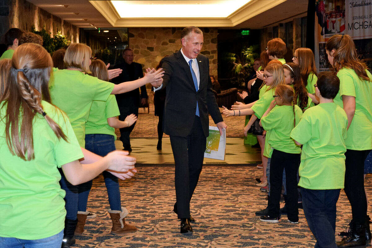Honorary Chairperson Jim Fitterling earns some high-fives from student volunteers during Thursday’s fundraising dinner event for The ROCK Center for Youth Development at the Great Hall in Midland.