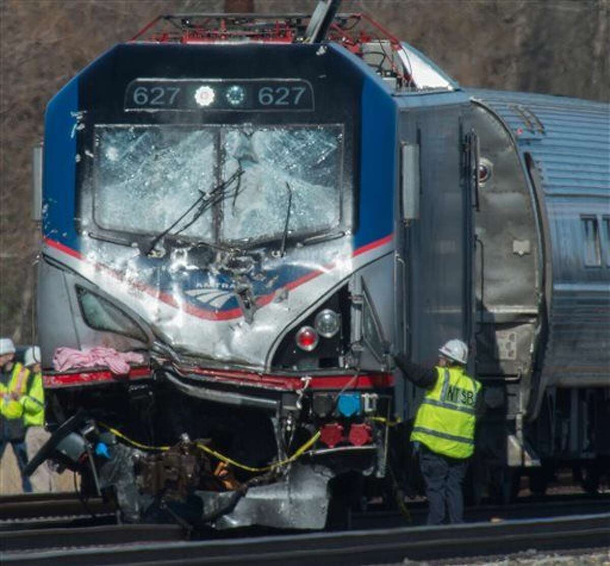 National Transportation Safety Board staffers inspect the engine of Amtrak Train 89 which hit a construction vehicle on the tracks and derailed in Chester, Pa., Sunday, April 3, 2016. The train was heading from New York to Savannah, Ga. (Clem Murray/The Philadelphia Inquirer via AP)