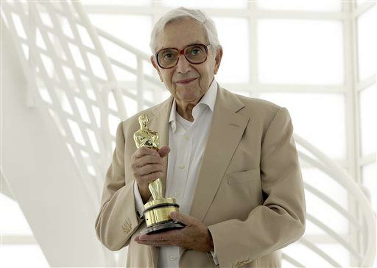 In this Sept. 3, 2012 file photo, German-born British production designer Ken Adam poses with his Oscar trophy in Berlin, Germany. Adam died at the age of 95. His death was confirmed Thursday by the official James Bond Twitter account. Adam’s death was first reported by the BBC, which said he died at his home in London.