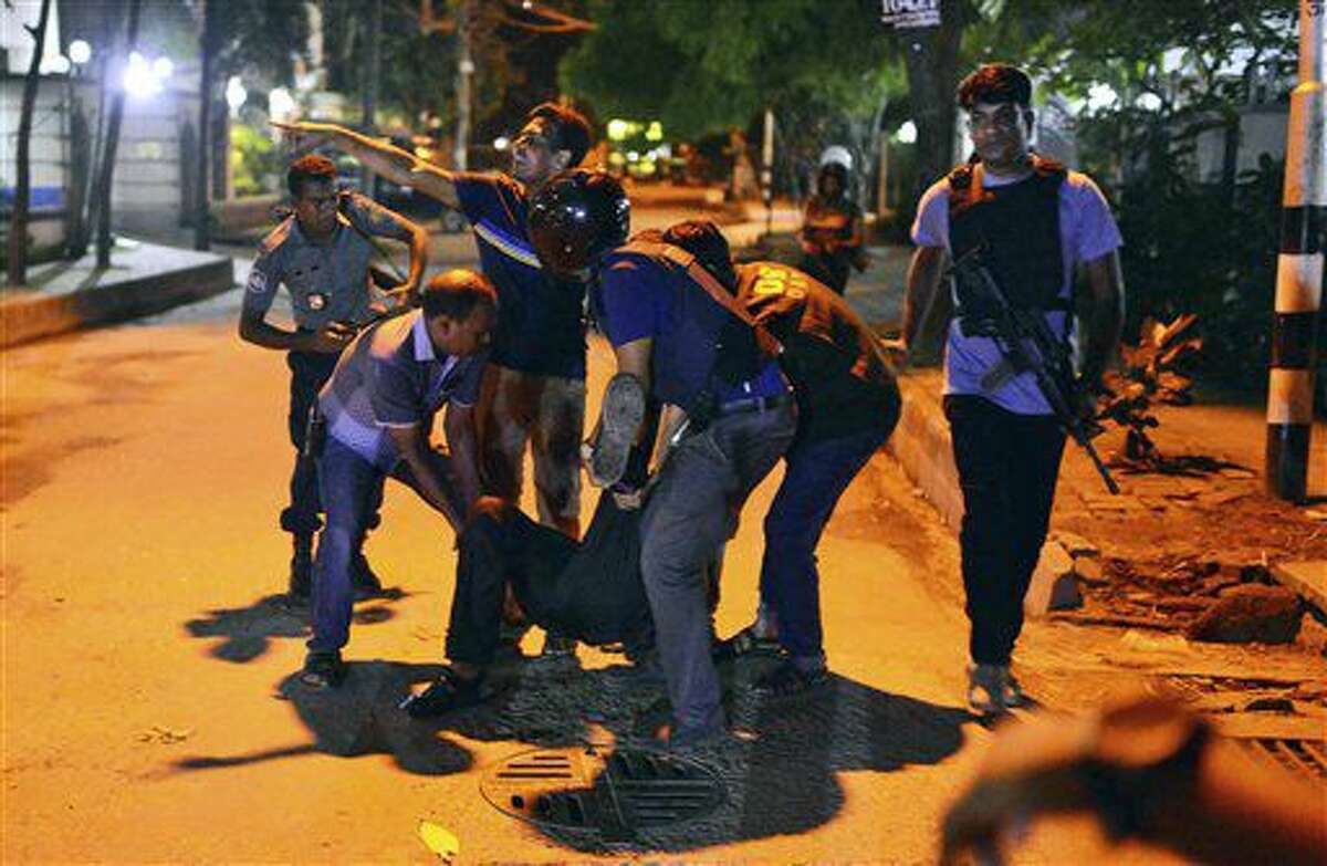 Un grupo de personas ayudan a un herido después que hombres armados atacaron un restaurante popular entre los extranjeros en una zona diplomática de Daca, la capital de Bangladesh, el viernes 1 de julio de 2016, donde tomaron rehenes e intercambiaron disparos con fuerzas de seguridad. (AP Foto)