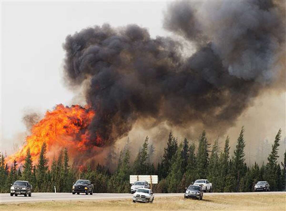 A wildfire burns south of Fort McMurray, Alberta, near Highway 63 on Saturday, May 7, 2016. Canadian officials hoped to complete the mass evacuation of work camps north of Alberta's main oil sands city of Fort McMurray on Saturday, fearing the growing wildfire could double in size and reach a major oil sands mine and even the neighboring province of Saskatchewan. (Ryan Remiorz/The Canadian Press via AP) MANDATORY CREDIT