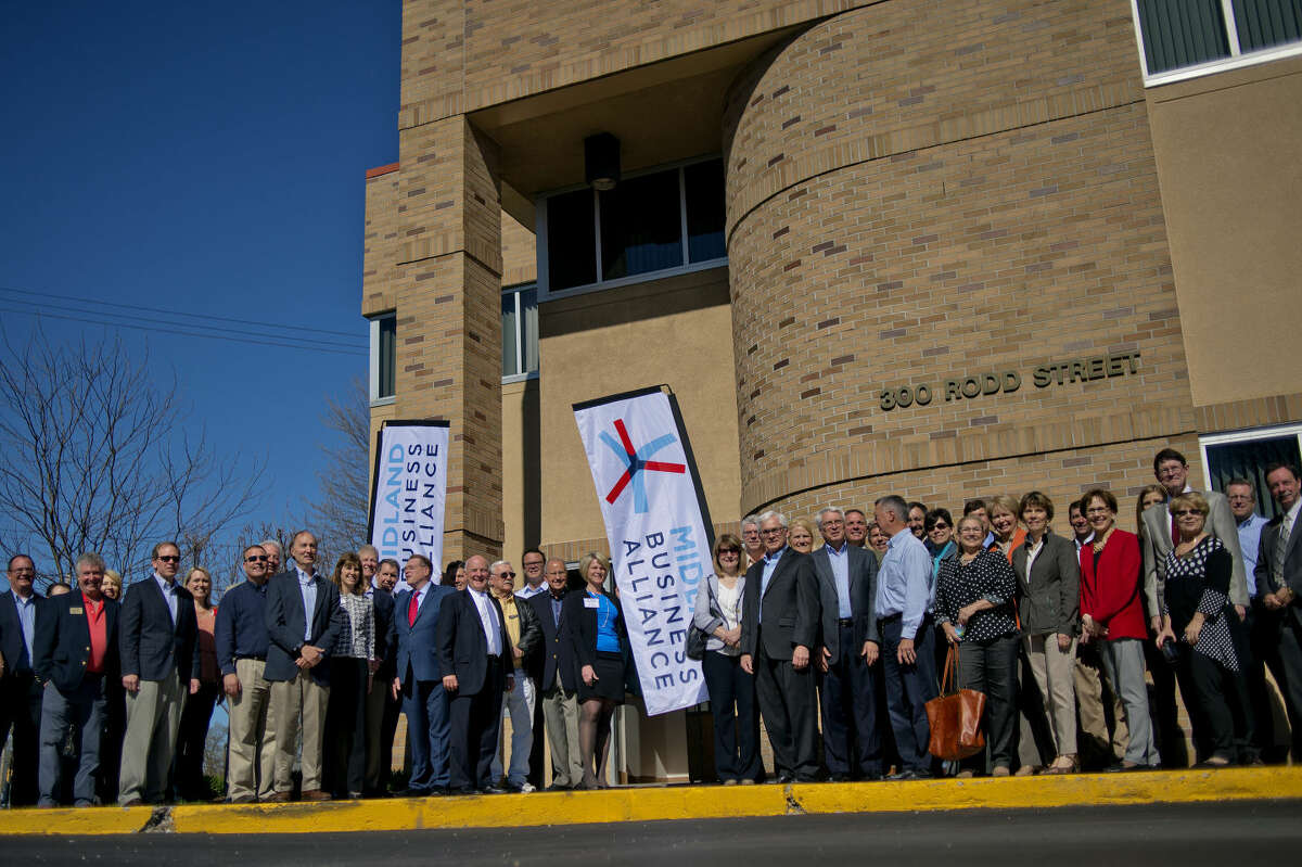 Business professionals pose outside of the Carl A. Gerstacker Commerce Center during the recent unveiling of the Midland Business Alliance.