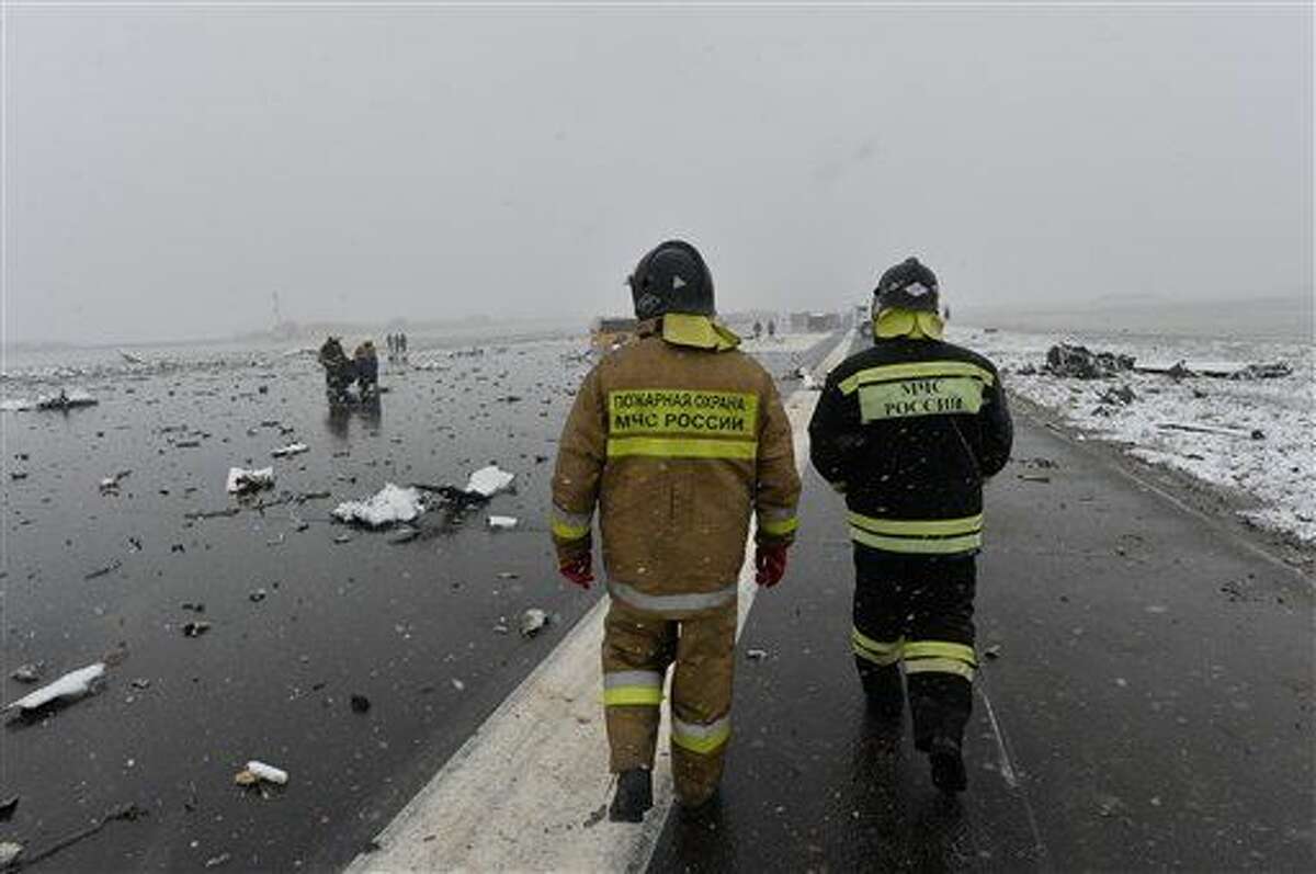 A Russian Emergency Ministry employee walk past the wreckage of a crashed plane at the Rostov-on-Don airport, about 950 kilometers (600 miles) south of Moscow, Russia Saturday, March 19, 2016. A Dubai airliner with 62 people on board nosedived and exploded in a giant fireball early Saturday while trying to land in strong winds in the southern Russian city of Rostov-on-Don, killing all aboard, officials said. (AP Photo)